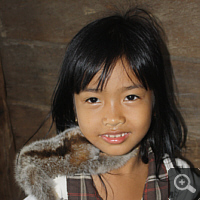 Siebenjähriges Dayak-Mädchen mit einem Halbaffen als Haustier.