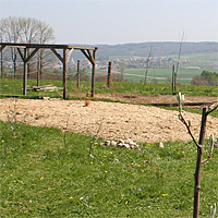 Im Frühjahr 2010. Inzwischen wurde eine etwa 30 cm hohe Flussschotterschicht eingebracht sowie eine etwa 2 cm hohe Lehmauflage, sowie eine Hecke ringsherum gepflanzt.